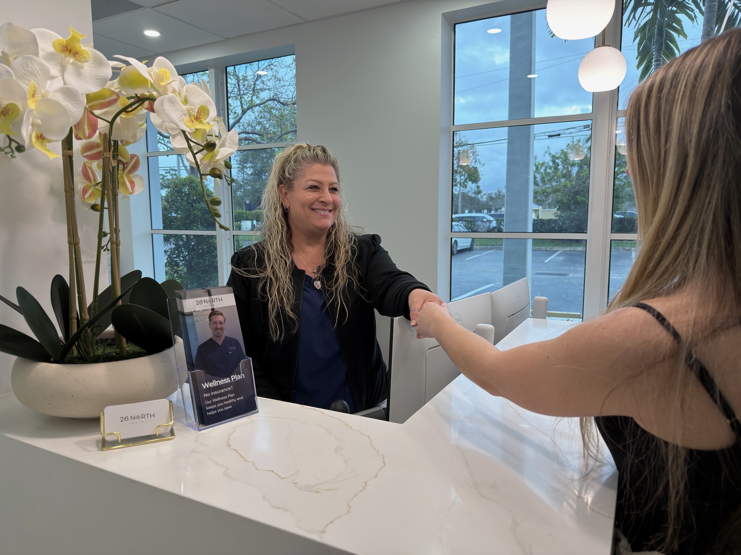 26 North Dental team member welcoming a patient at the front desk